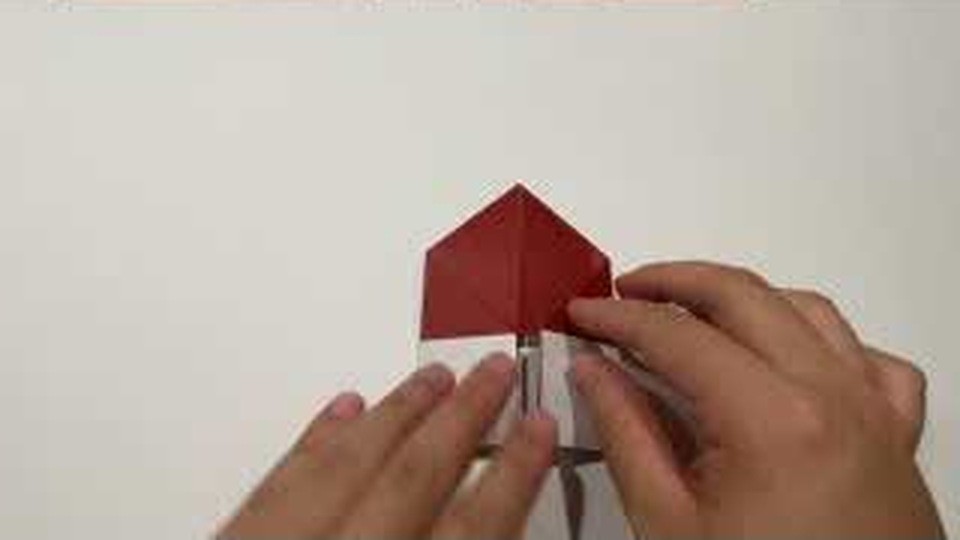 三角の左右の角を折り込み、かさの形を作っているところ