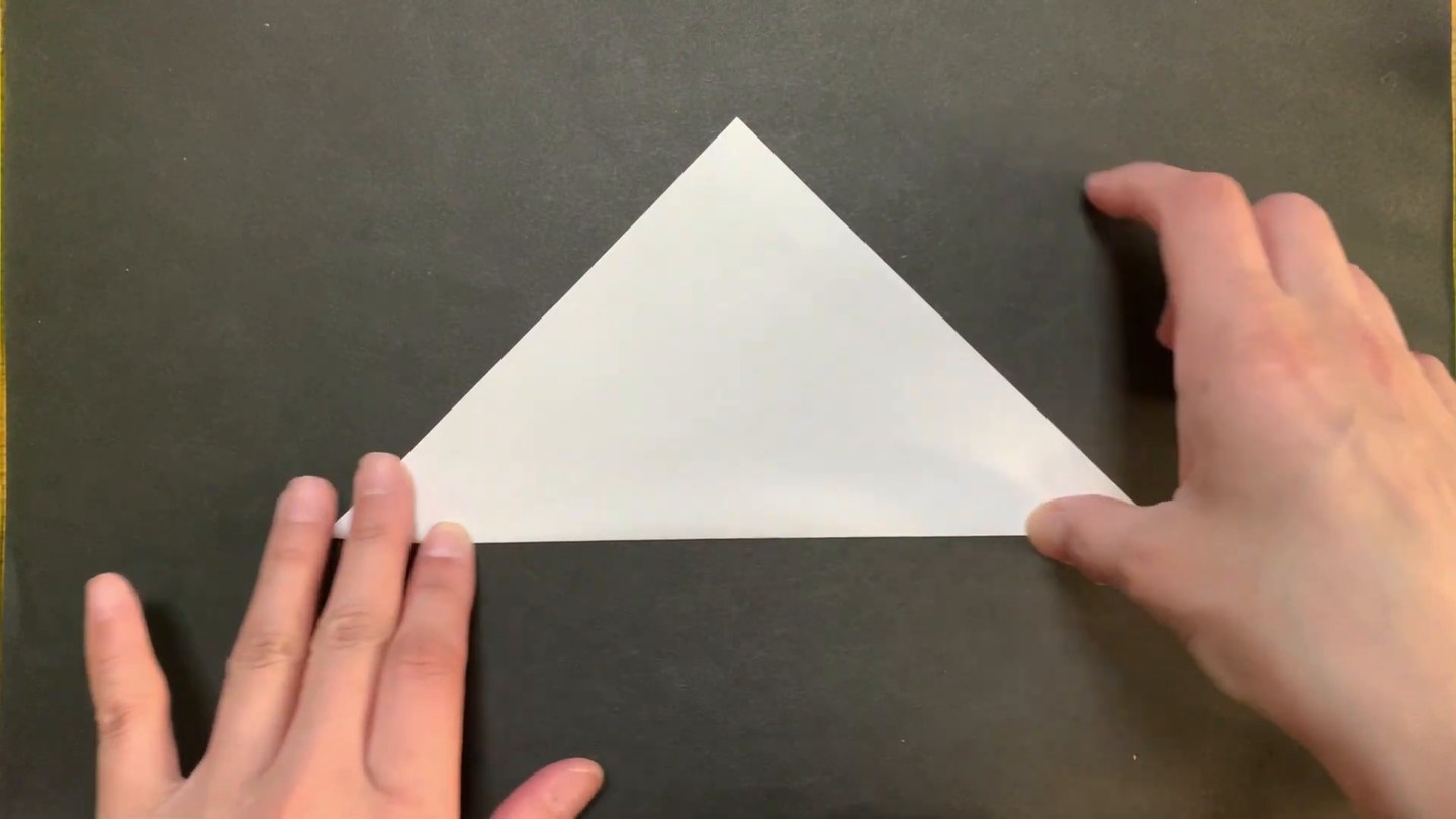 白い折り紙を三角に折ったところ
